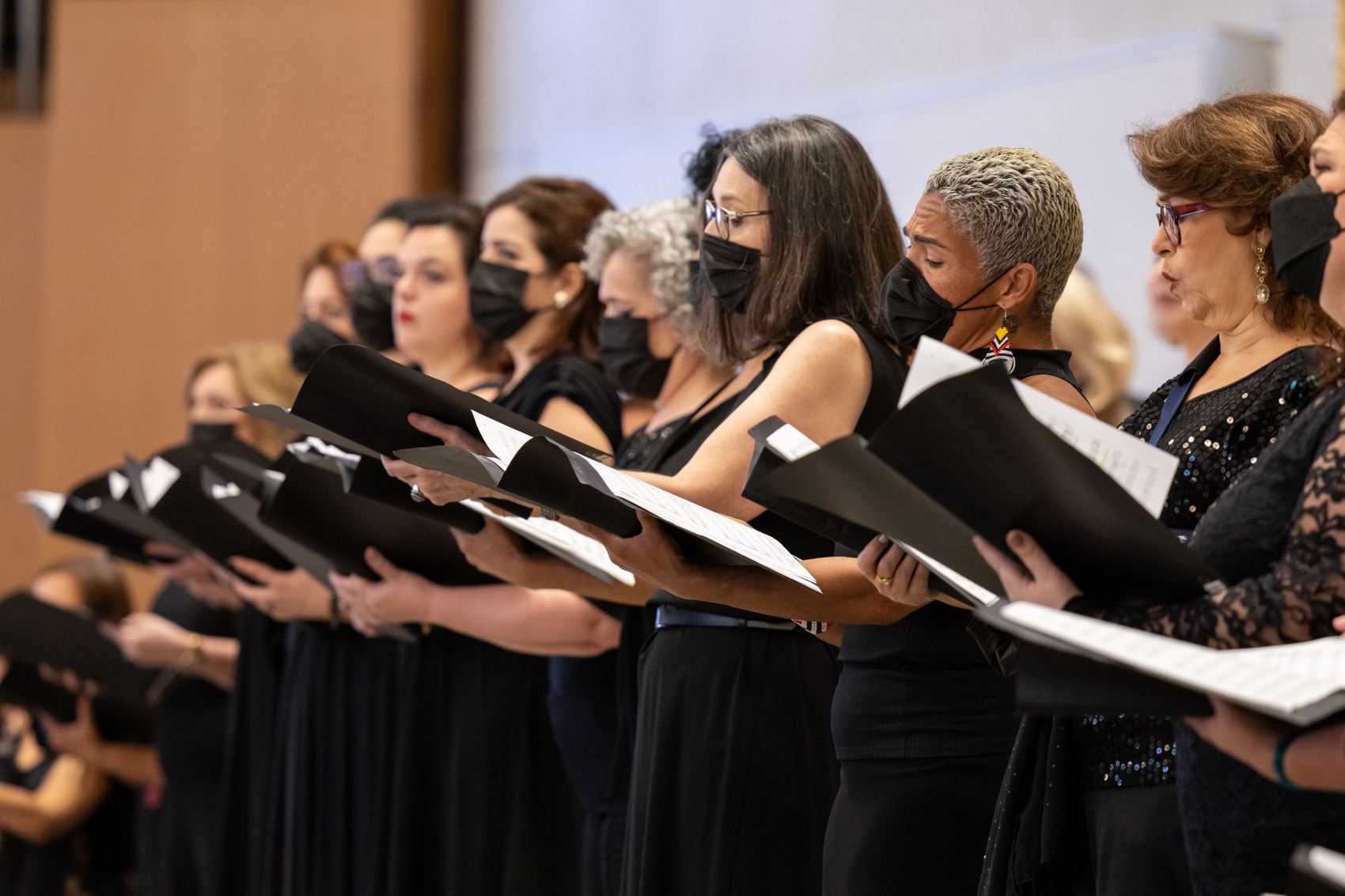 Foto de integrantes do Coro cantando durante uma apresentação