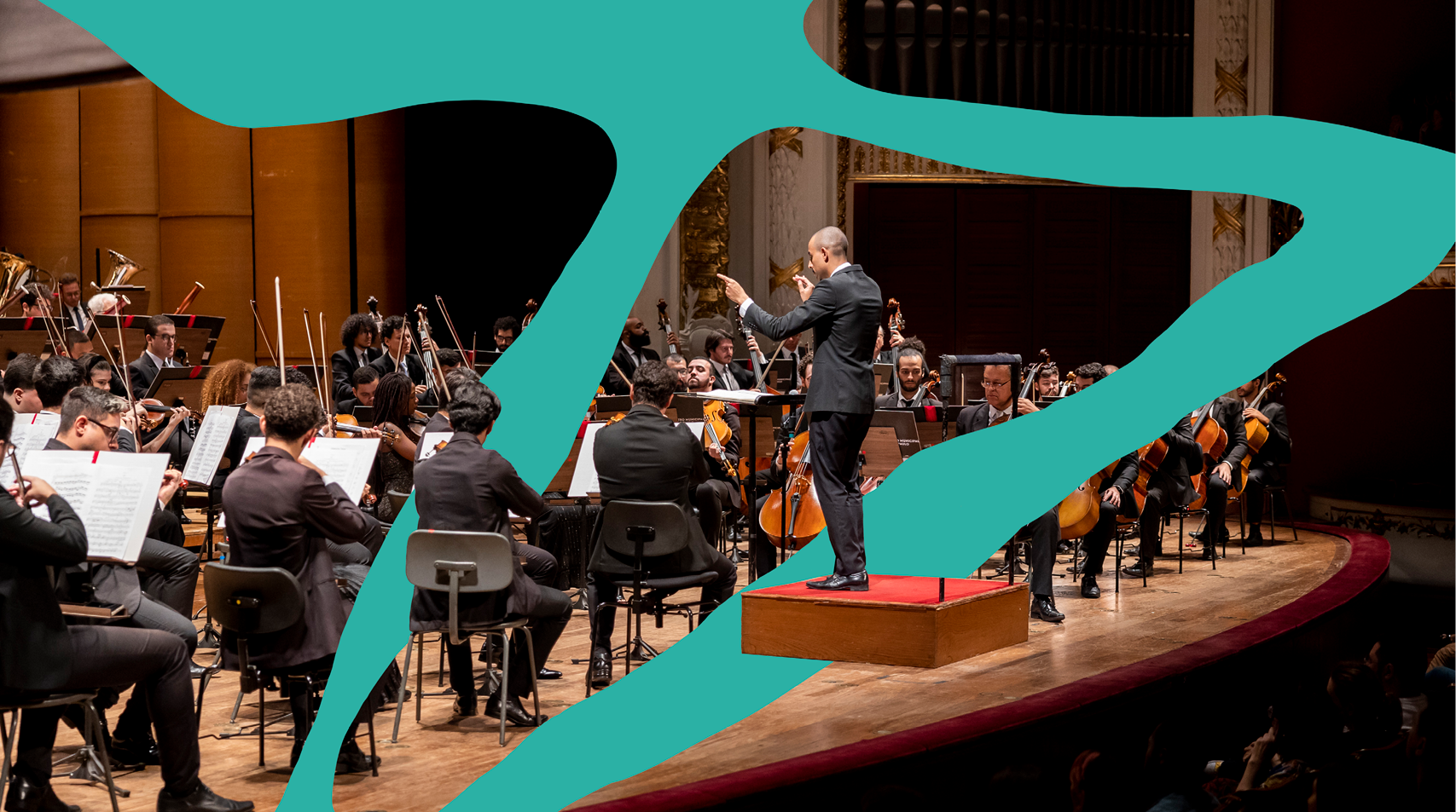 Foto de orquestra tocando com maestro a frente