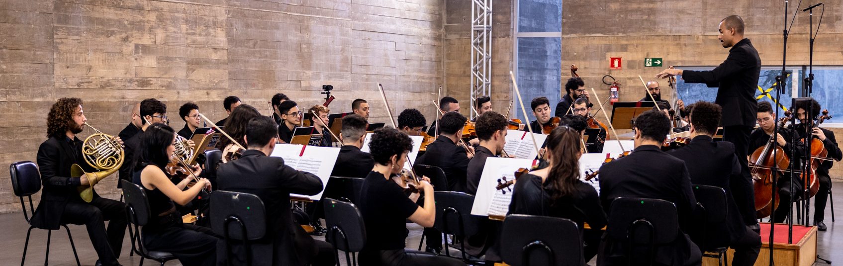 Foto da Orquestra completa tocando durante um concerto