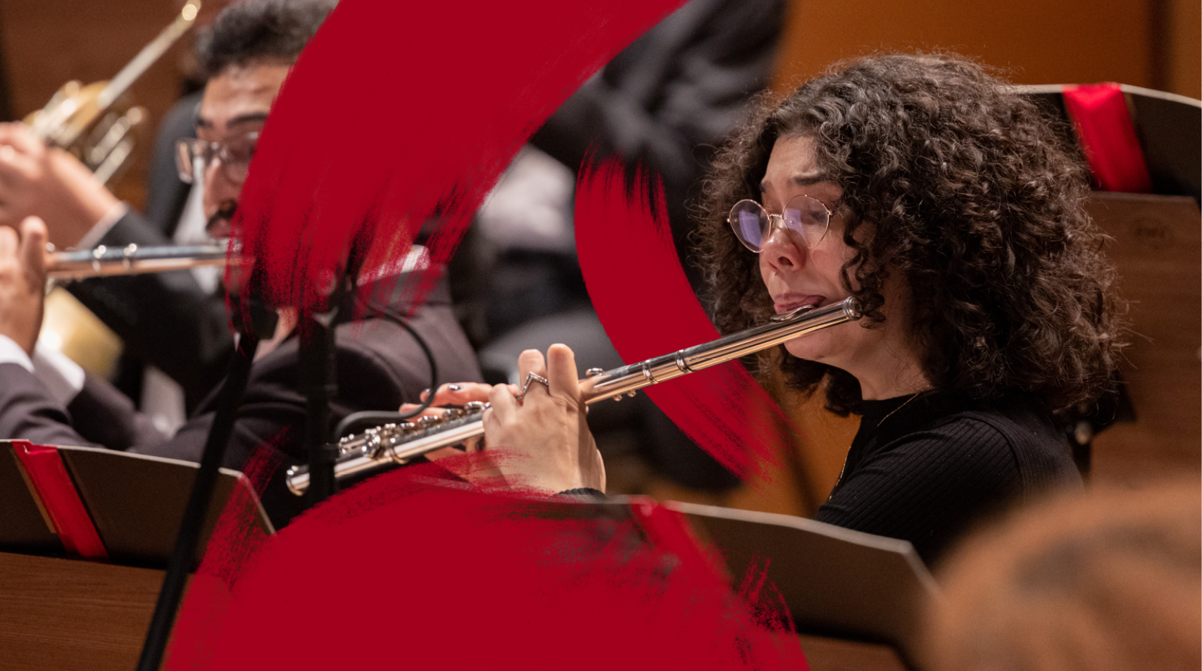 Foto de musicista da Orquestra Experimental de Repertório tocando instrumento de sopro durante um concerto