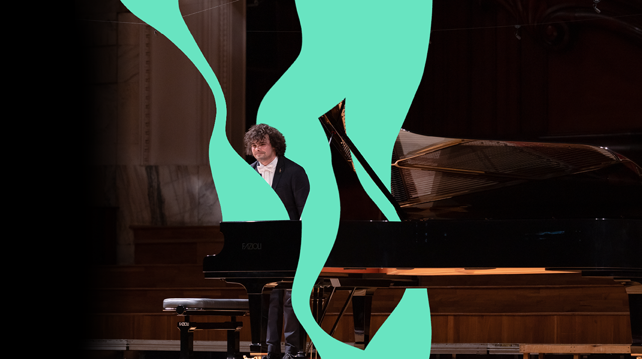 Foto de pianista branco com cabelos cacheados inclinado em pé atrás de um piano no palco